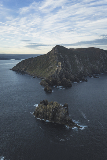 Aerial view of rugged coastal cliffs and rocky islets surrounded by the deep blue Atlantic Ocean in Galicia Spain.