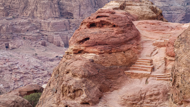 View of ancient rock cut stairs carved into the red sandstone cliffs of the Petra archaeological site in Wadi Musa Ma an Governorate Jordan. View of ancient rock cut stairs carved into the red sandstone cliffs of the Petra archaeological site in Wadi Musa Ma an Governorate Jordan.