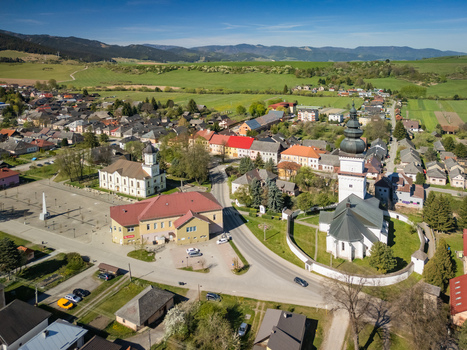 Aerial view of St. Matthew s Church and the historic town square surrounded by traditional houses and rolling green hills under a clear blue sky in Partizanska Lupca Zilina Region Slovakia. Aerial view of St. Matthew s Church and the historic town square surrounded by traditional houses and rolling green hills under a clear blue sky in Partizanska Lupca Zilina Region Slovakia.
