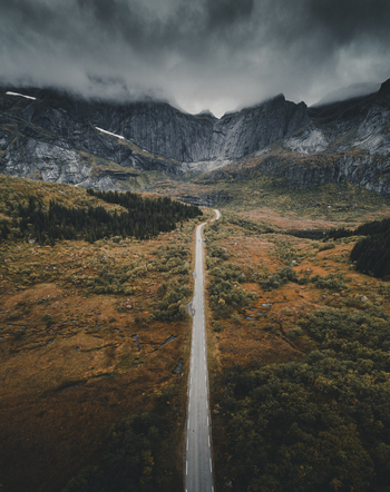 Aerial view of the Batman wall mountain range with a long road stretching through the autumn landscape in Ramberg Nordland Norway. Aerial view of the Batman wall mountain range with a long road stretching through the autumn landscape in Ramberg Nordland Norway.