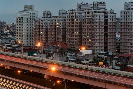 View of high rise residential buildings and an elevated highway with light trails at dusk in Sanchong District New Taipei City Taiwan. View of high rise residential buildings and an elevated highway with light trails at dusk in Sanchong District New Taipei City Taiwan.