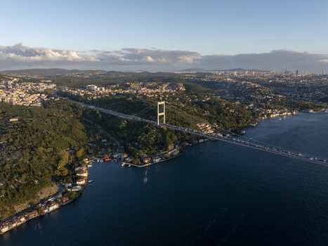 Aerial view of Fatih Sultan Mehmet Bridge spanning the Bosphorus with lush green hills and urban development in Beykoz Istanbul Turkiye. Aerial view of Fatih Sultan Mehmet Bridge spanning the Bosphorus with lush green hills and urban development in Beykoz Istanbul Turkiye.