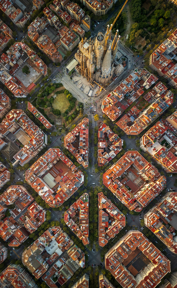 Aerial view of the Sagrada Familia basilica surrounded by the dense urban grid and historic rooftops of Barcelona Catalonia Spain. Aerial view of the Sagrada Familia basilica surrounded by the dense urban grid and historic rooftops of Barcelona Catalonia Spain.
