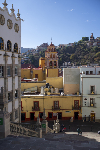 View of the historic architecture and colorful buildings of Guanajuato Capital with stone stairs in the foreground under a clear blue sky in Guanajuato Guanajuato Mexico. View of the historic architecture and colorful buildings of Guanajuato Capital with stone stairs in the foreground under a clear blue sky in Guanajuato Guanajuato Mexico.