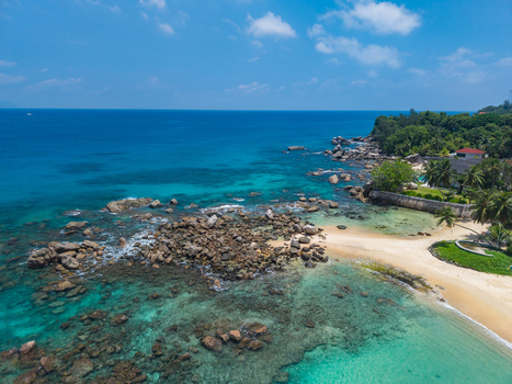 Aerial view of the turquoise waters meeting the rocky coastline a tropical haven bathed in sunlight Vista do Mar Mahe island Seychelles. Aerial view of the turquoise waters meeting the rocky coastline a tropical haven bathed in sunlight Vista do Mar Mahe island Seychelles.
