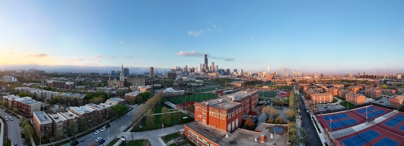 Aerial view of the Chicago skyline featuring the Willis Tower urban residential blocks and sports fields under a clear blue sky in Chicago. Aerial view of the Chicago skyline featuring the Willis Tower urban residential blocks and sports fields under a clear blue sky in Chicago.