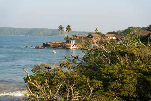 View of the historic Galle Fort walls and palm trees overlooking the calm ocean water under a clear sky Galle Southern Province Sri Lanka.