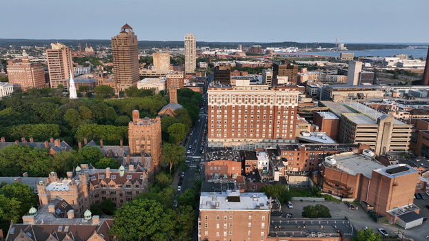 Aerial view of the New Haven cityscape featuring historic university architecture dense urban buildings and the harbor in the distance in New Haven Connecticut United States. Aerial view of the New Haven cityscape featuring historic university architecture dense urban buildings and the harbor in the distance in New Haven Connecticut United States.