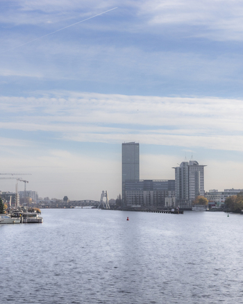 View of the Spree river with the Molecule Man sculpture and modern office buildings under a blue sky with light clouds in Berlin Berlin Germany. View of the Spree river with the Molecule Man sculpture and modern office buildings under a blue sky with light clouds in Berlin Berlin Germany.