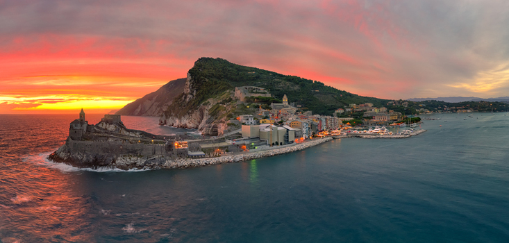 Aerial view of Chiesa di San Pietro on a rocky promontory during a vibrant sunset with colorful clouds over the coastal town of Portovenere Liguria Italy. Aerial view of Chiesa di San Pietro on a rocky promontory during a vibrant sunset with colorful clouds over the coastal town of Portovenere Liguria Italy.