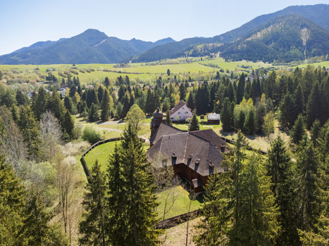Aerial view of the Wooden Articular Church of Svaty Kriz nestled among dense pine forests and rolling green hills in Svaty Kriz Zilinsky kraj Slovakia.