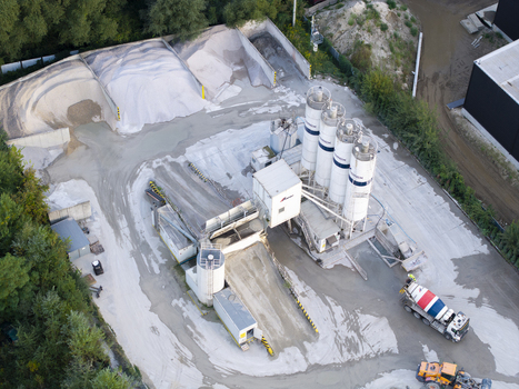 Krakow Poland 16 September 2026 Aerial view of CEMEX Polska concrete batching plant with tall silos aggregate storage piles and a cement mixer truck on site. Krakow Poland 16 September 2026 Aerial view of CEMEX Polska concrete batching plant with tall silos aggregate storage piles and a cement mixer truck on site.