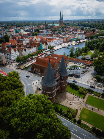 Aerial view of the iconic Holsten Gate guarding the historic city with its red brick contrasting against the lush greenery L&uuml;beck Schleswig Holstein Germany.