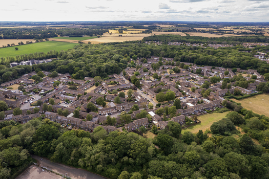Aerial view of Bretton Park featuring residential housing estates surrounded by dense green woodland and agricultural fields in Peterborough England United Kingdom. Aerial view of Bretton Park featuring residential housing estates surrounded by dense green woodland and agricultural fields in Peterborough England United Kingdom.