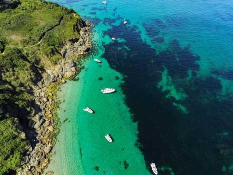 Aerial view of the rocky coastline and turquoise waters of Ile de Groix with anchored boats along the shore Groix Bretagne France. Aerial view of the rocky coastline and turquoise waters of Ile de Groix with anchored boats along the shore Groix Bretagne France.