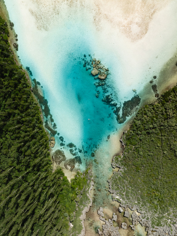 Aerial view of the striking contrast between the verdant forest and the turquoise waters of Oro Natural Pool L Île des Pins New Caledonia. Aerial view of the striking contrast between the verdant forest and the turquoise waters of Oro Natural Pool L Île des Pins New Caledonia.
