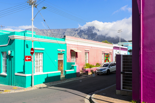 View of vibrant colorful houses in the Bo Kaap neighborhood with Table Mountain visible in the background Cape Town Western Cape South Africa. View of vibrant colorful houses in the Bo Kaap neighborhood with Table Mountain visible in the background Cape Town Western Cape South Africa.