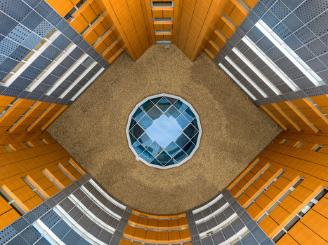 Aerial view of a modern building courtyard featuring a central glass dome skylight surrounded by geometric wooden and metal facades in Belgrade City of Belgrade Serbia. Aerial view of a modern building courtyard featuring a central glass dome skylight surrounded by geometric wooden and metal facades in Belgrade City of Belgrade Serbia.