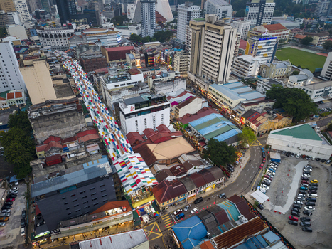 Kuala Lumpur Malaysia 09 March 2026 Aerial view of the colorful Petaling Street market canopy in Chinatown surrounded by historic shophouses and modern urban architecture.
