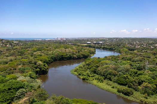 Aerial view of the Haina River winding through the lush green forests and vegetation of the Engombe area in Santo Domingo Oeste Santo Domingo Dominican Republic.