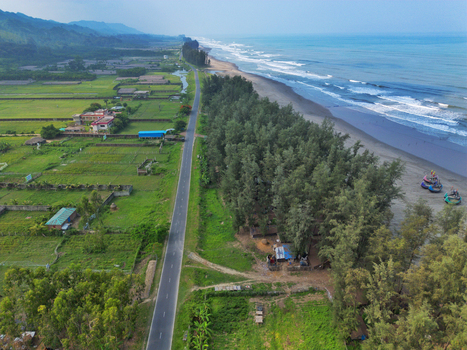 Aerial view of the long sandy coastline and Marine Drive road lined with lush green trees and agricultural fields in Cox s Bazar Chittagong Division Bangladesh. Aerial view of the long sandy coastline and Marine Drive road lined with lush green trees and agricultural fields in Cox s Bazar Chittagong Division Bangladesh.