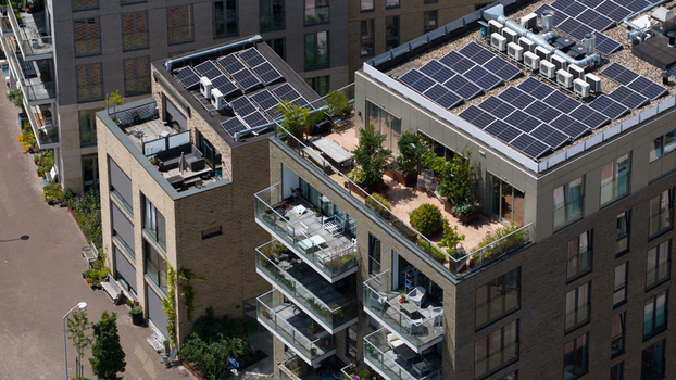Aerial view of modern apartment buildings with rooftop solar panels and green terraces along Cruquiusweg in Amsterdam Noord Holland Netherlands.