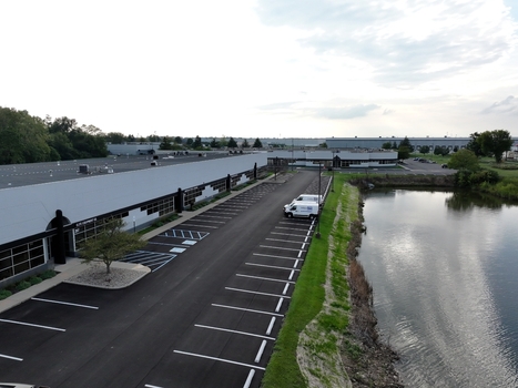 Aerial view of a modern industrial building with a large parking lot and a nearby retention pond in Indianapolis Indiana United States. Aerial view of a modern industrial building with a large parking lot and a nearby retention pond in Indianapolis Indiana United States.