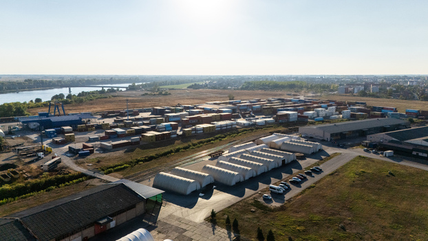 Sremska Mitrovica Serbia 16 September 2026 Aerial view of a logistics terminal with shipping containers industrial warehouses and arched storage structures near the Sava River. Sremska Mitrovica Serbia 16 September 2026 Aerial view of a logistics terminal with shipping containers industrial warehouses and arched storage structures near the Sava River.
