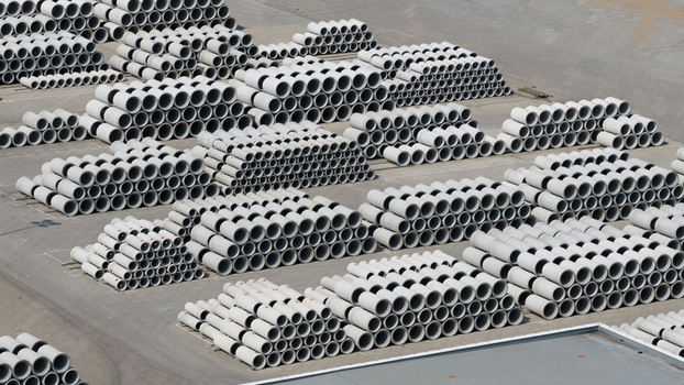 Aerial view of neatly stacked concrete pipes in an industrial storage yard under bright daylight Oosterhout North Brabant Netherlands. Aerial view of neatly stacked concrete pipes in an industrial storage yard under bright daylight Oosterhout North Brabant Netherlands.