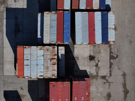 Aerial view of colorful shipping containers stacked in an industrial yard with long shadows on the concrete ground Cincinnati OH United States.