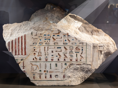 Giza Egypt 16 May 2026 View of an ancient stone fragment featuring colorful hieroglyphics on display at the Grand Egyptian Museum.