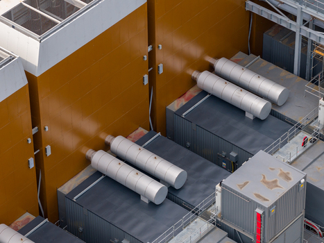 Aerial view of the industrial infrastructure at Ark Data Centres in Longcross Park featuring large ventilation units and metallic piping on the facility roof in Chertsey England United Kingdom. Aerial view of the industrial infrastructure at Ark Data Centres in Longcross Park featuring large ventilation units and metallic piping on the facility roof in Chertsey England United Kingdom.