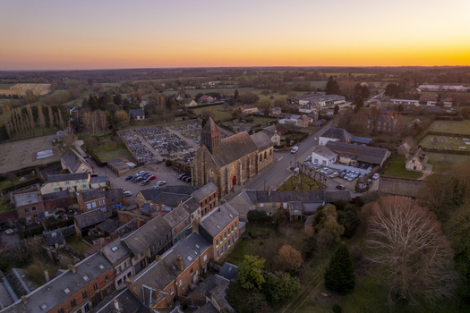 Aerial view of the historic church and cemetery surrounded by rural houses and fields in Sap en Auge Normandy France. Aerial view of the historic church and cemetery surrounded by rural houses and fields in Sap en Auge Normandy France.