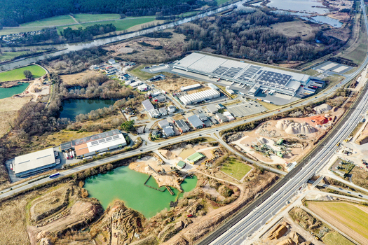 Aerial view of an industrial park with large warehouses and a sand quarry featuring a green pond near the Main Danube Canal in Forchheim Bavaria Germany. Aerial view of an industrial park with large warehouses and a sand quarry featuring a green pond near the Main Danube Canal in Forchheim Bavaria Germany.