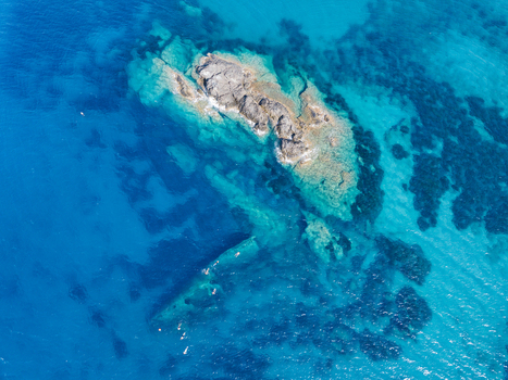 Aerial view of the Elviscot shipwreck resting in the clear turquoise waters near the rocky coastline of Pomonte Province of Livorno Italy.