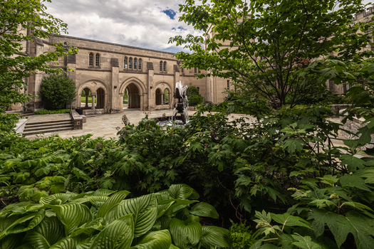 Washington District of Columbia United States 06 May 2025 View of the Bishop s Garden fountain at Washington National Cathedral with lush foliage and stone archways.