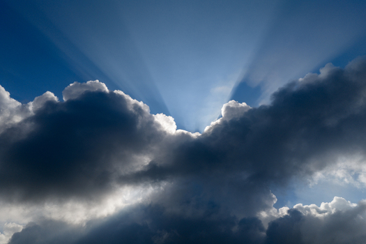 Aerial view of bright sunbeams breaking through dark storm clouds against a blue sky in Klobouky u Brna Jihomoravsky kraj Czechia. Aerial view of bright sunbeams breaking through dark storm clouds against a blue sky in Klobouky u Brna Jihomoravsky kraj Czechia.
