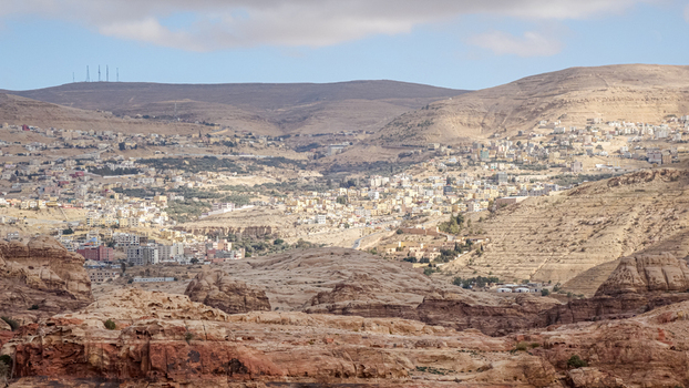 View of the town of Wadi Musa nestled among the arid rocky hills and desert landscape in Wadi Musa Ma an Governorate Jordan. View of the town of Wadi Musa nestled among the arid rocky hills and desert landscape in Wadi Musa Ma an Governorate Jordan.