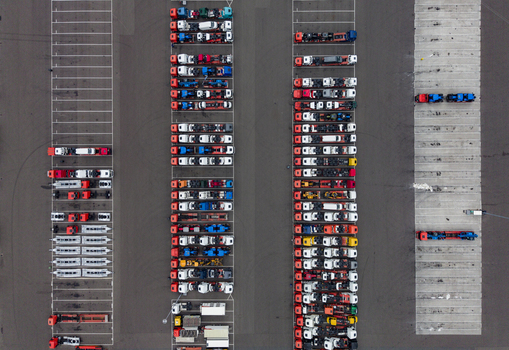 Aerial view of the Ekkersrijt 2037 logistics hub with rows of parked trucks and trailers on an asphalt lot in Son Noord Brabant Netherlands.
