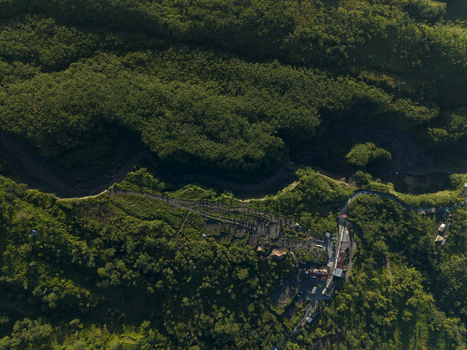 Aerial view of Bunker Kaliadem Merapi surrounded by dense tropical forest winding roads and cold lava rivers on the slopes of Mount Merapi Pakem Yogyakarta Indonesia. Aerial view of Bunker Kaliadem Merapi surrounded by dense tropical forest winding roads and cold lava rivers on the slopes of Mount Merapi Pakem Yogyakarta Indonesia.