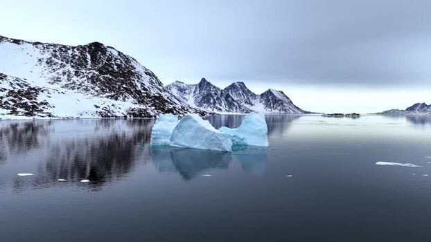 Aerial view of an iceberg in calm water near Tasiilaq Greenland. Aerial view of an iceberg in calm water near Tasiilaq Greenland.