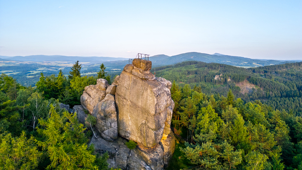 Aerial view of the Popova Skala rock formation surrounded by dense green forests and rolling hills in Hradek nad Nisou Liberec Region Czechia. Aerial view of the Popova Skala rock formation surrounded by dense green forests and rolling hills in Hradek nad Nisou Liberec Region Czechia.