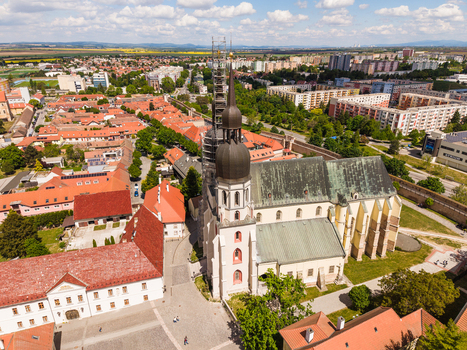 Aerial view of the Gothic St. Nicholas Basilica with its distinct twin towers and red rooftops surrounded by historic city walls and urban landscape in Trnava Trnava Region Slovakia. Aerial view of the Gothic St. Nicholas Basilica with its distinct twin towers and red rooftops surrounded by historic city walls and urban landscape in Trnava Trnava Region Slovakia.