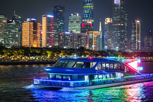 Guangzhou Guangdong Province China 22 February 2024 View of a brightly illuminated cruise boat sailing on the Pearl River at night with the modern city skyline in the background. Guangzhou Guangdong Province China 22 February 2024 View of a brightly illuminated cruise boat sailing on the Pearl River at night with the modern city skyline in the background.