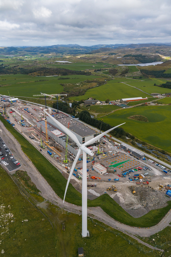 Aerial view of Green Mountain SVG Undheim Datasenter with a wind turbine construction cranes and industrial buildings set amidst green rolling hills in Undheim Rogaland Norway. Aerial view of Green Mountain SVG Undheim Datasenter with a wind turbine construction cranes and industrial buildings set amidst green rolling hills in Undheim Rogaland Norway.