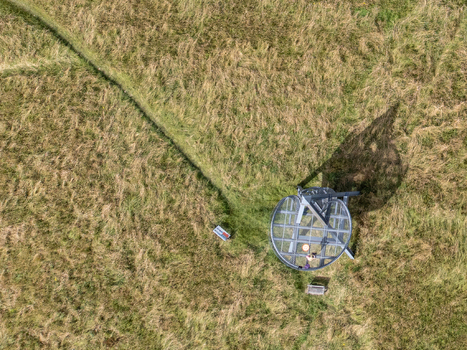 Aerial view of a metal observation tower standing amidst a field of golden grass casting a long shadow Uitkijktoren Hemelrijkse Waard Noord Brabant Netherlands. Aerial view of a metal observation tower standing amidst a field of golden grass casting a long shadow Uitkijktoren Hemelrijkse Waard Noord Brabant Netherlands.