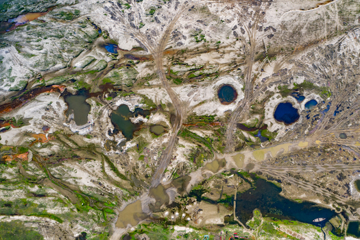 Aerial view of the sandy terrain with scattered water pools and vehicle tracks in Panchagarh Rangpur Division Bangladesh. Aerial view of the sandy terrain with scattered water pools and vehicle tracks in Panchagarh Rangpur Division Bangladesh.