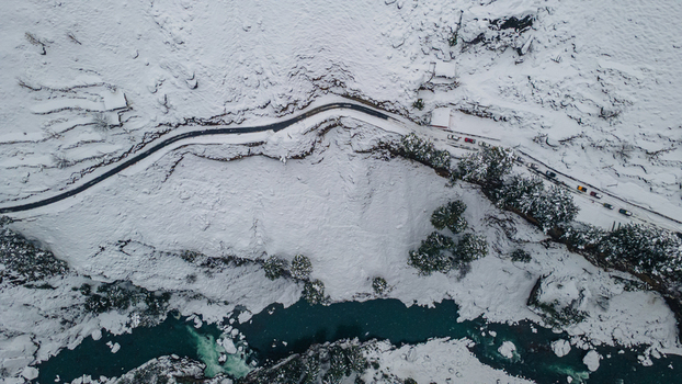 Aerial view of a winding road cutting through the snow laden landscape alongside a turquoise river a stark contrast of cold whites and vibrant blues Sharda Azad Kashmir Pakistan. Aerial view of a winding road cutting through the snow laden landscape alongside a turquoise river a stark contrast of cold whites and vibrant blues Sharda Azad Kashmir Pakistan.