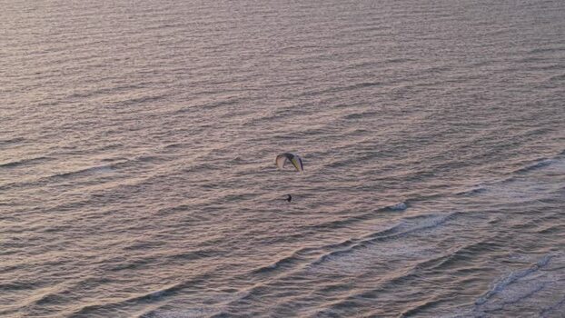 Aerial view of paraglider over the sea near Rubjerg Knude Denmark.