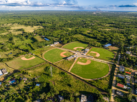 Aerial view of Quality Baseball Academy featuring multiple baseball fields and lush green surroundings in San Antonio de Guerra Santo Domingo Provinc Dominican Republic. Aerial view of Quality Baseball Academy featuring multiple baseball fields and lush green surroundings in San Antonio de Guerra Santo Domingo Provinc Dominican Republic.